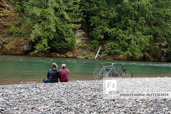 Rückansicht eines Paares am Flussufer mit Blick in die Ferne  Packwood  Washington  USA