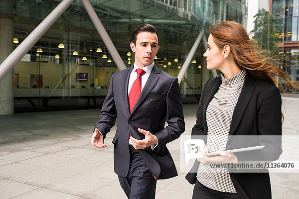 Businesspeople in city walking and talking