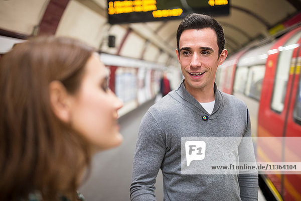 Man on railway platform talking to friend