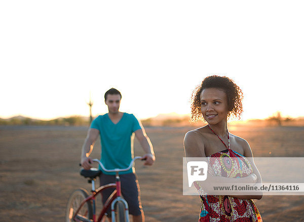 Junges Paar steht bei Sonnenuntergang in der Wüste