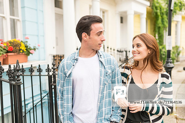 Couple walking in street face to face smiling
