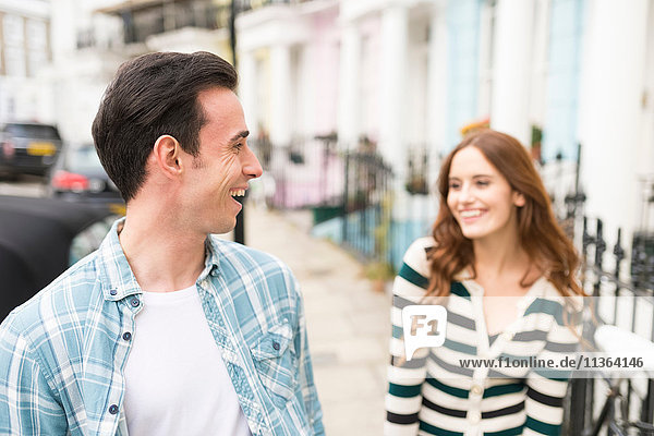 Paar in der Straße von Angesicht zu Angesicht lächelnd