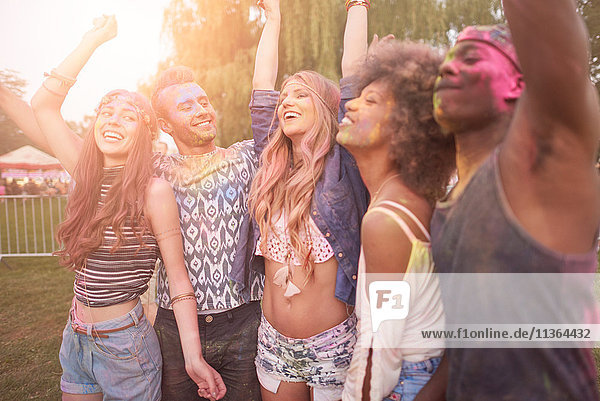 Group of friends at festival  covered in colourful powder paint