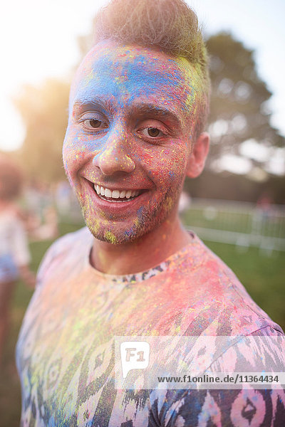 Porträt eines jungen Mannes beim Festival  bedeckt mit bunter Pulverfarbe