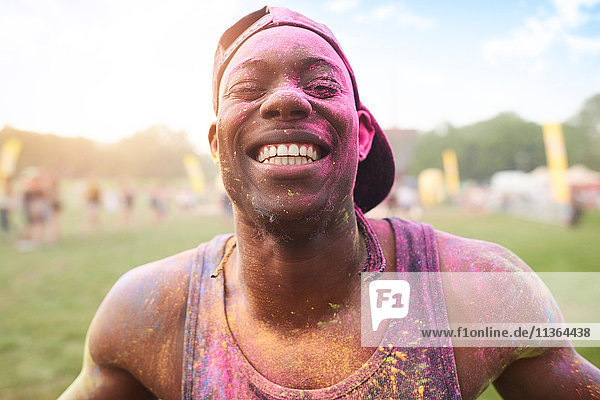 Porträt eines jungen Mannes beim Festival  bedeckt mit bunter Pulverfarbe