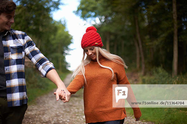 Paar hält sich beim Gehen auf Feldwegen an den Händen