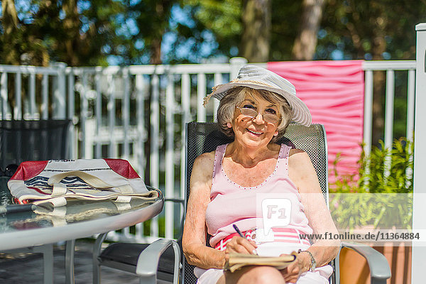 Senior woman relaxing with book on deckchair