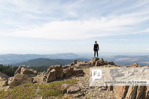 Junge Frau steht auf Fels und schaut auf Aussicht  Silver Star Mountain  Washington  USA