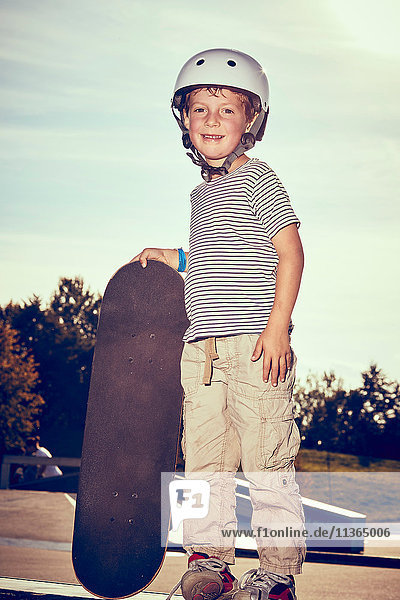 Boy with skateboard in park