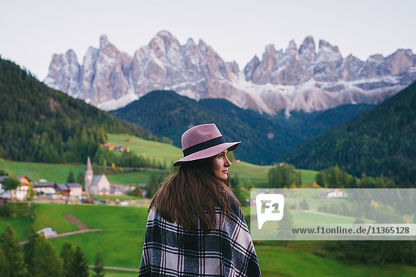 Woman looking over shoulder  Santa Maddalena  Dolomite Alps  Val di Funes (Funes Valley)  South Tyrol  Italy