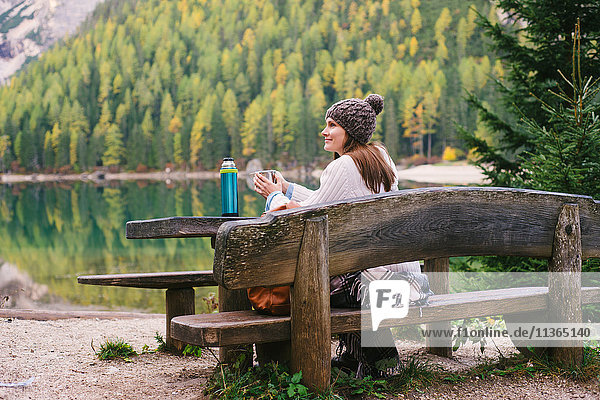 Woman relaxing on park bench  Lago di Braies  Dolomite Alps  Val di Braies  South Tyrol  Italy