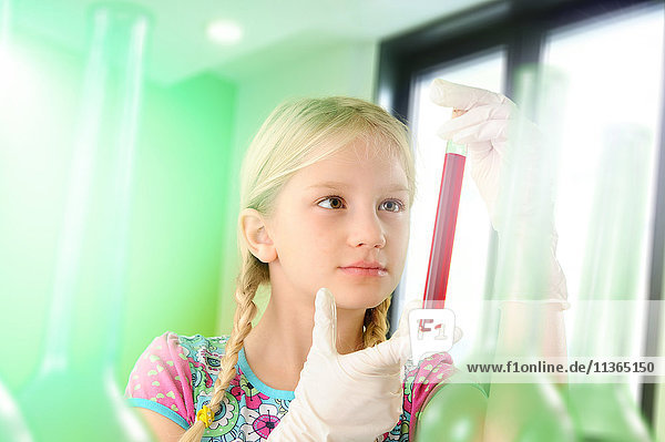 Mädchen  das sich als Wissenschaftlerin ausgibt und ein Reagenzglas untersucht