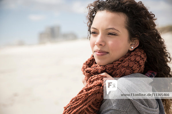 Young woman wrapped in scarf looking out to sea from beach  Western Cape  South Africa
