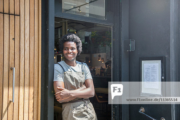 Porträt des Kellners in der Tür des städtischen Straßencafés