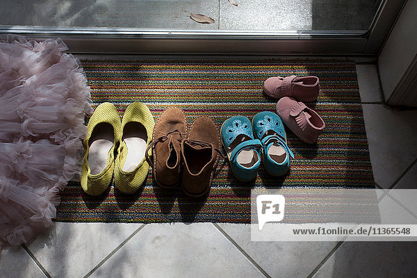 Schuhe verschiedener Größen auf der Fußmatte aufgereiht