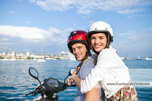 Portrait of young couple riding moped at harbour  Split  Dalmatia  Croatia