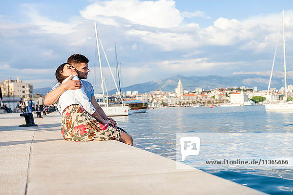 Young couple sitting on harbour  Split  Dalmatia  Croatia