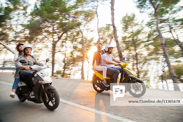 Two couples riding mopeds along coastal road  Split  Dalmatia  Croatia