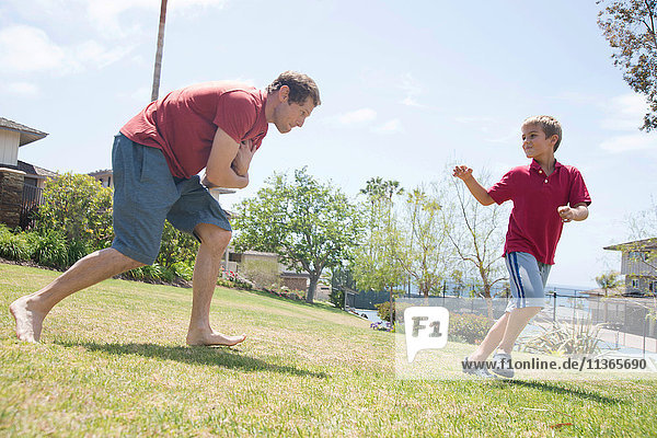 Man and son practicing american football in park