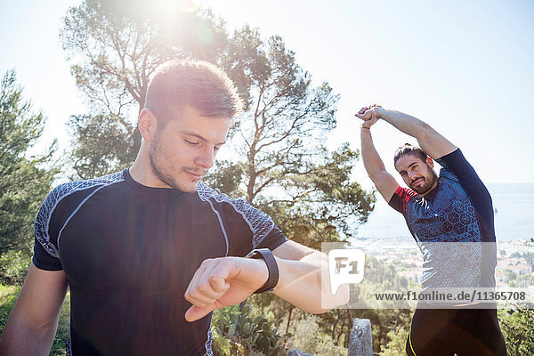 Männlicher Läufer kontrolliert Smartwatch im Park  Split  Dalmatien  Kroatien