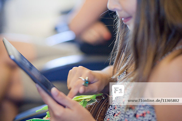 Girl using digital tablet in airplane
