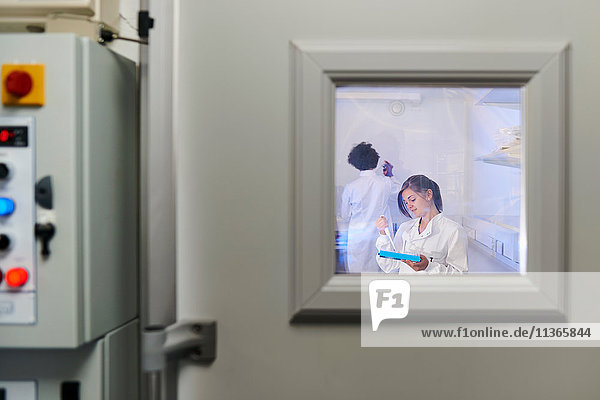 View through window of scientists in laboratory