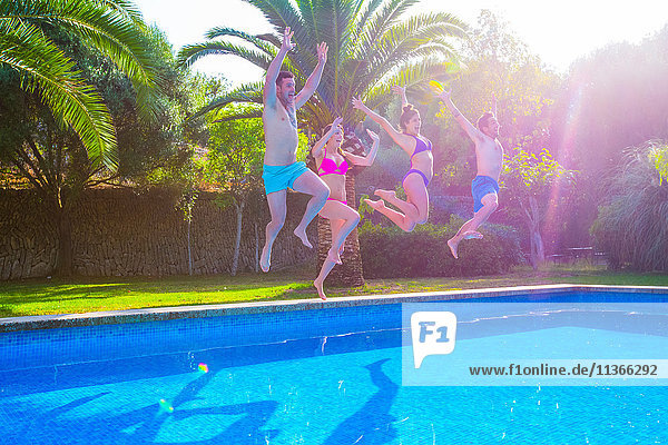 Freunde springen gemeinsam ins Schwimmbad