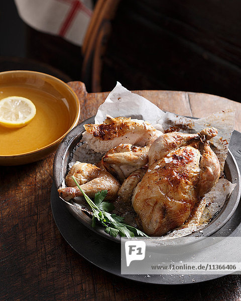 Bistro-Mahlzeit aus gebratenem Huhn im Korb mit Petersilie auf dem Tisch