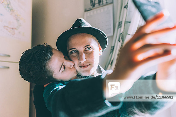 Junges lesbisches Paar nimmt Smartphone-Selfie in der Küche