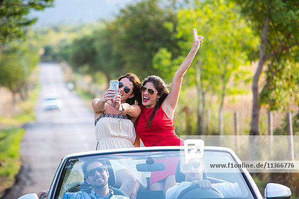 Zwei junge Freundinnen beim Selfie-Fahren auf der Landstraße im Cabriolet  Mallorca  Spanien