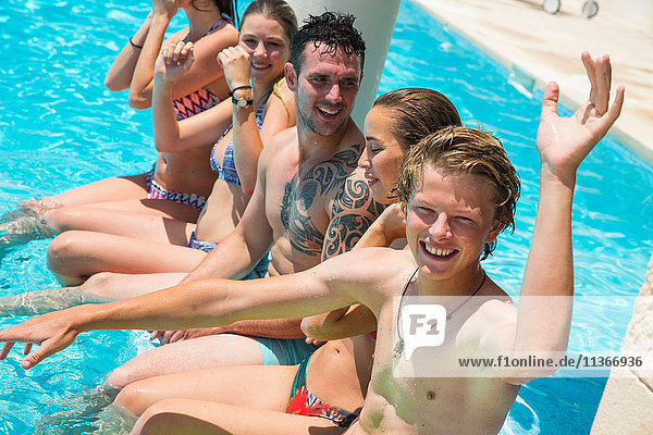 Five adult friends having fun in boutique hotel swimming pool  Majorca  Spain