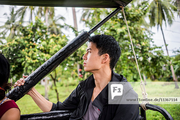 Young man sitting in back of jeep  Koh Samui  Thailand