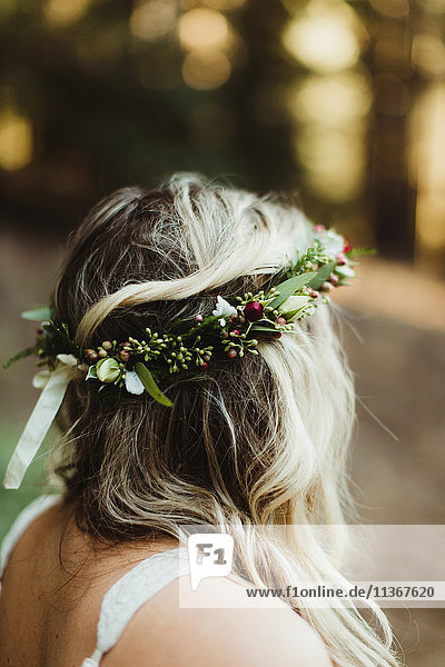 Rückansicht einer Frau mit Blumen im Haar  die wegschaut