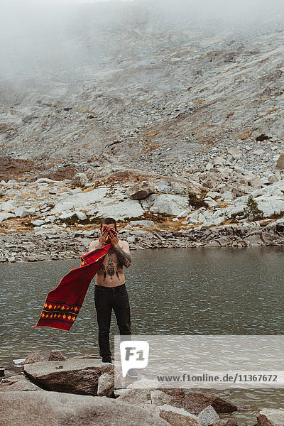 Junger männlicher Wanderer trocknet Gesicht mit Handtuch am See  Mineral King  Sequoia National Park  Kalifornien  USA