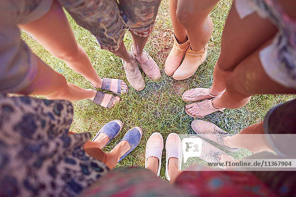 Gruppe von Freunden beim Fest  mit bunter Pulverfarbe überzogen  im Kreis stehend  erhöhte Ansicht der Füße