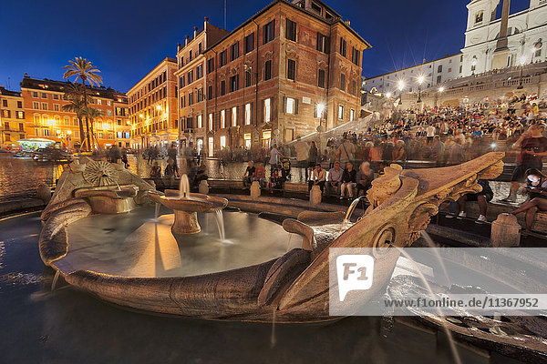 Touristen sitzen auf der Spanischen Treppe am Brunnen  Piazza di Spagna  Rom  Italien