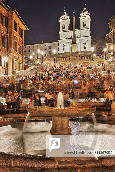 Tourists sitting on Spanish Steps at fountain  Piazza di Spagna  Rome  Italy