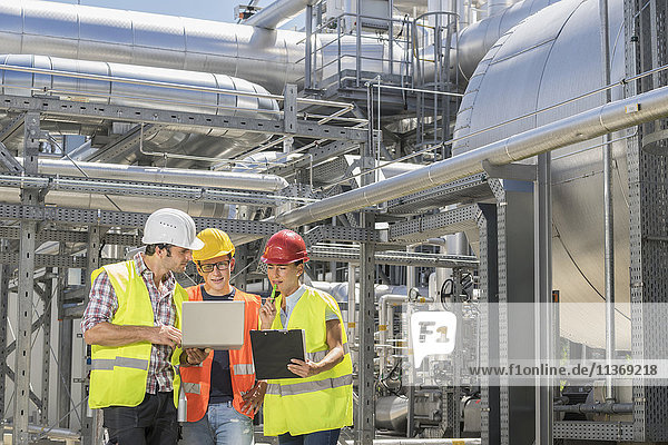 Ingenieur mit seinen Kollegen bei einer Besprechung mit Laptop im geothermischen Kraftwerk