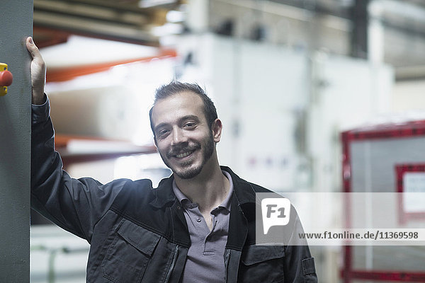 Porträt eines jungen männlichen Ingenieurs im Technikraum und lächelnd