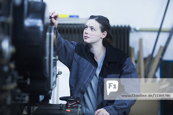 Print worker adjusting printing machine in an industry