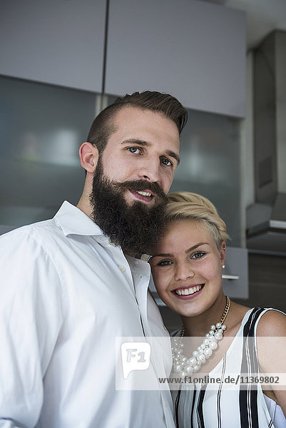 Portrait of a young couple standing in the kitchen