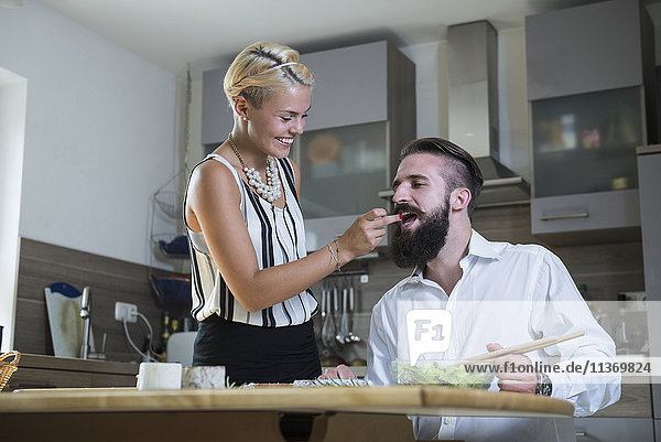 Woman feeding man in the kitchen