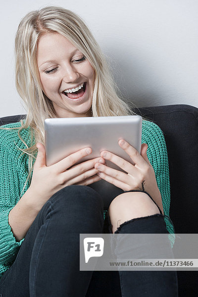 Young woman relaxing with digital tablet on sofa