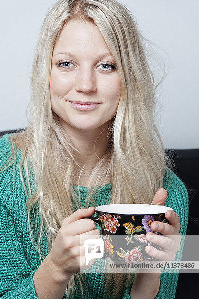 Porträt einer jungen Frau mit Kaffeetasse