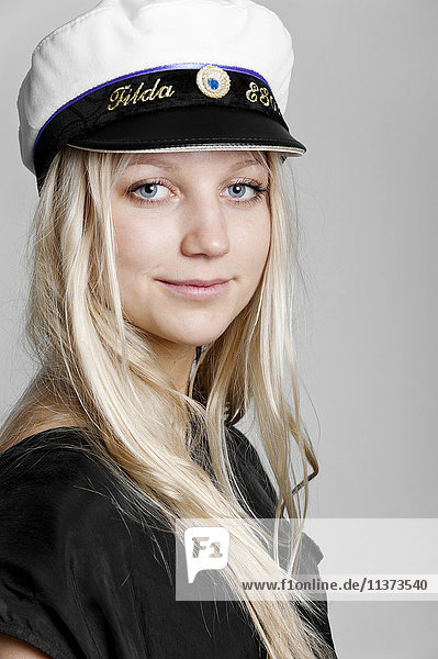 Portrait of young woman wearing captains hat