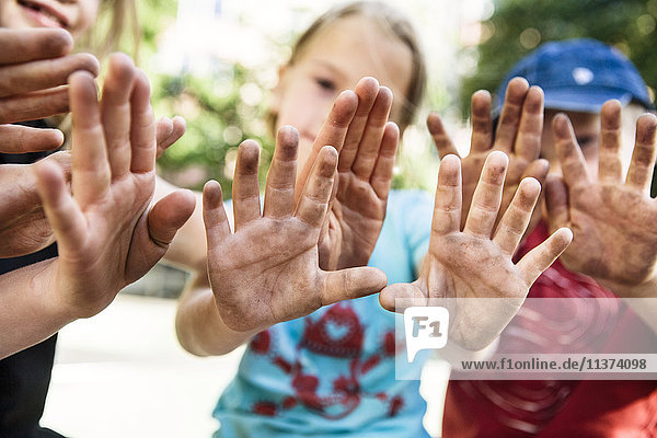 Kinder mit schmutzigen Händen