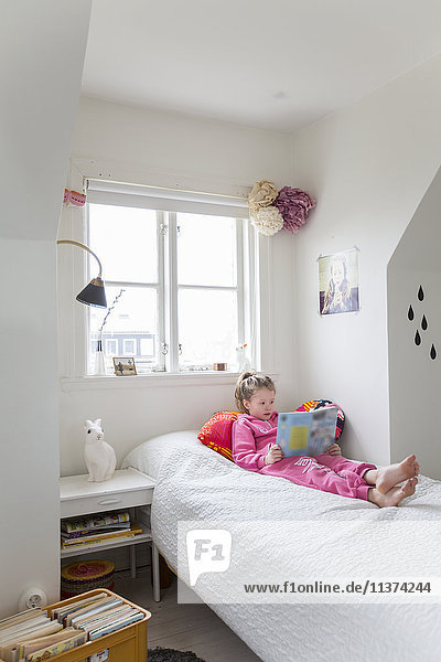 Mädchen liest Buch in ihrem Schlafzimmer