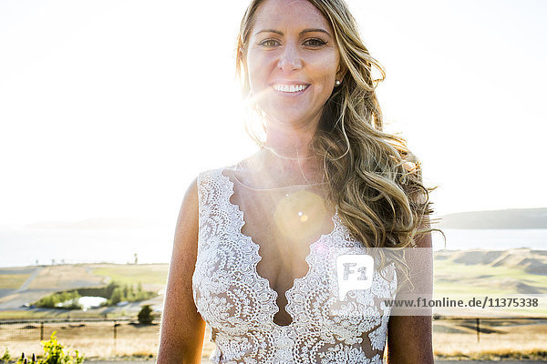 Kaukasische Braut lächelnd am sonnigen Tag
