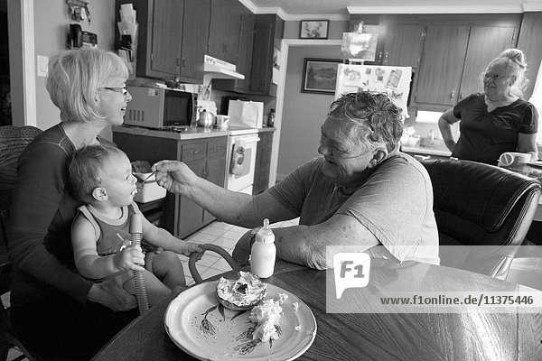 Kaukasischer Großvater füttert Enkel in der Küche