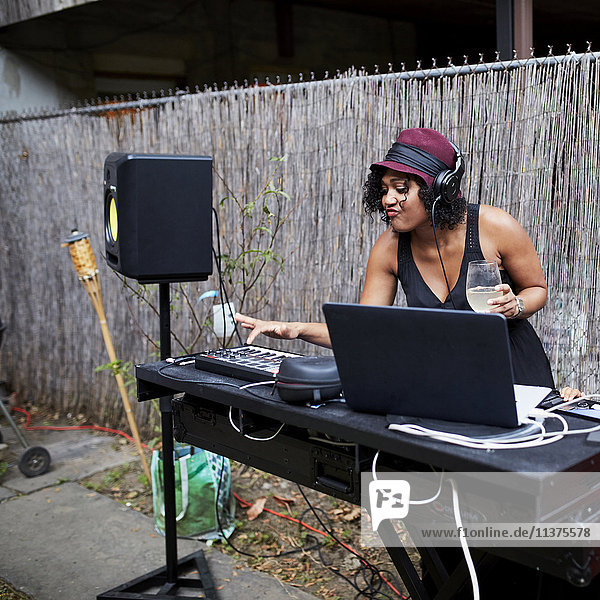 Mixed Race dj playing music in backyard
